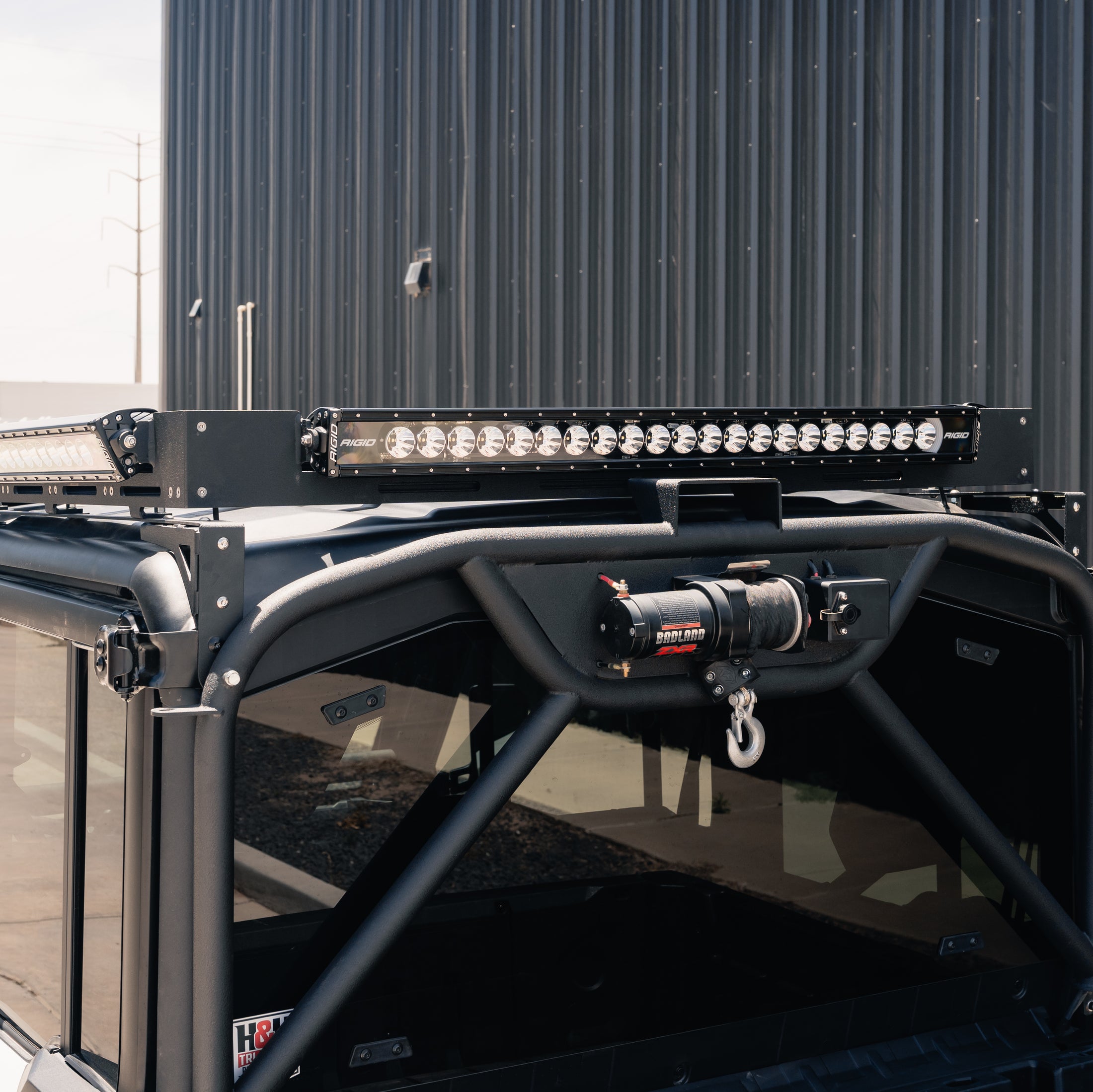 Roof rack with LED light bar on a vehicle, against a building background