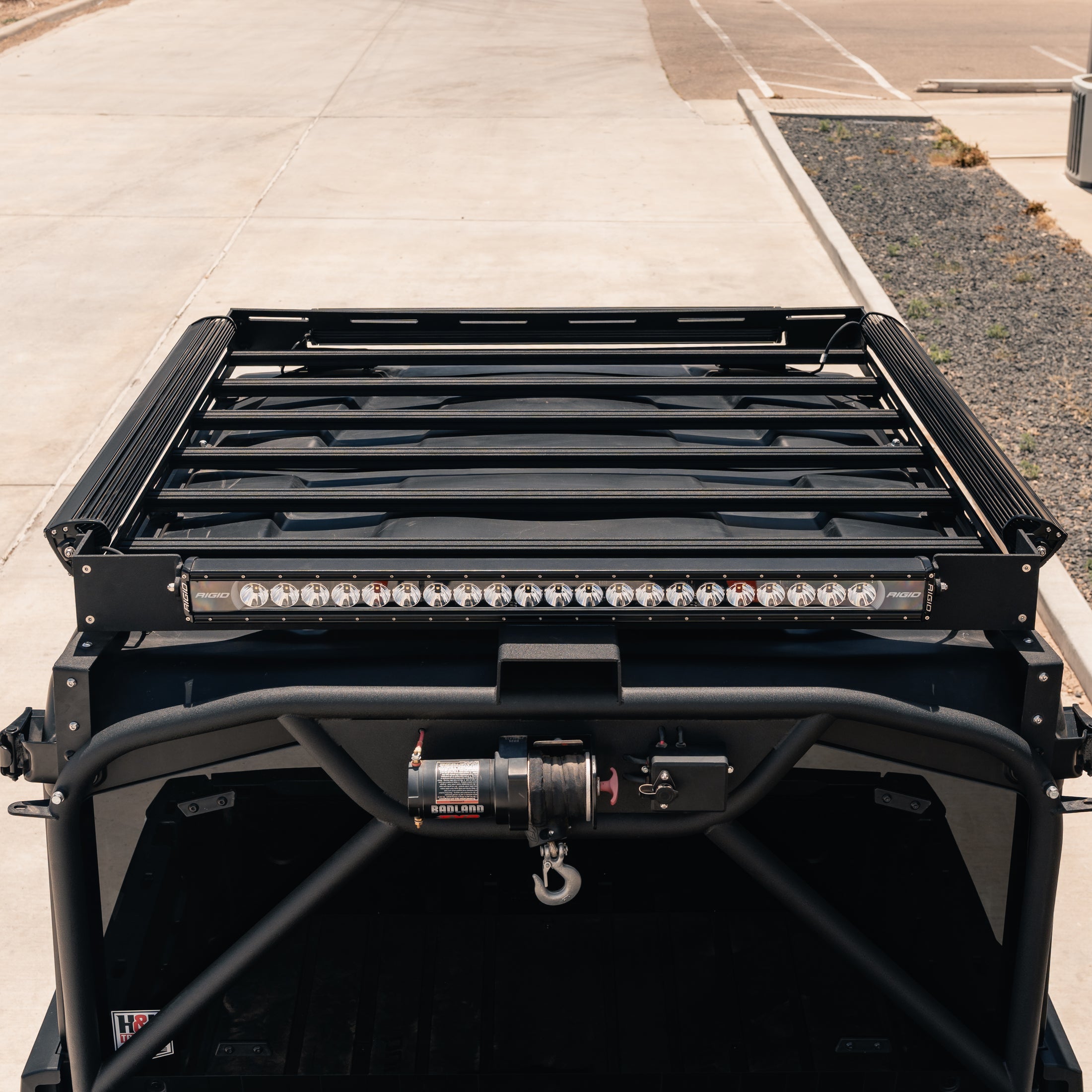 Black roof rack system on a vehicle with LED lights in an outdoor setting